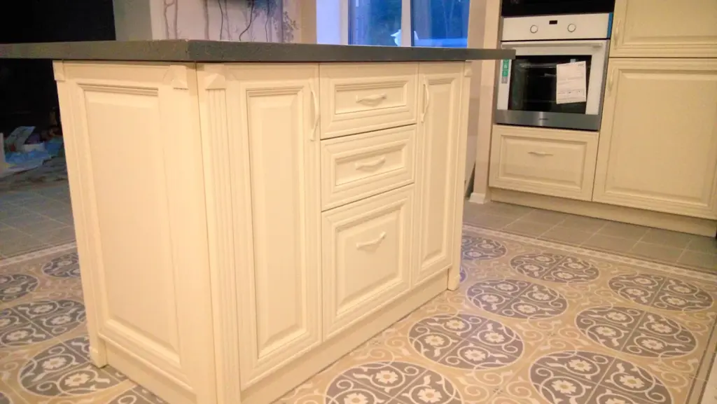 Остров светлой классической кухни с ящиками и шкафами
